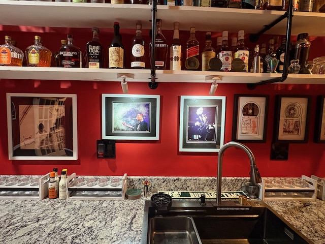 The L7067 Bar showing the Frank Sinatra and Mac Miller signed pieces on the red wall